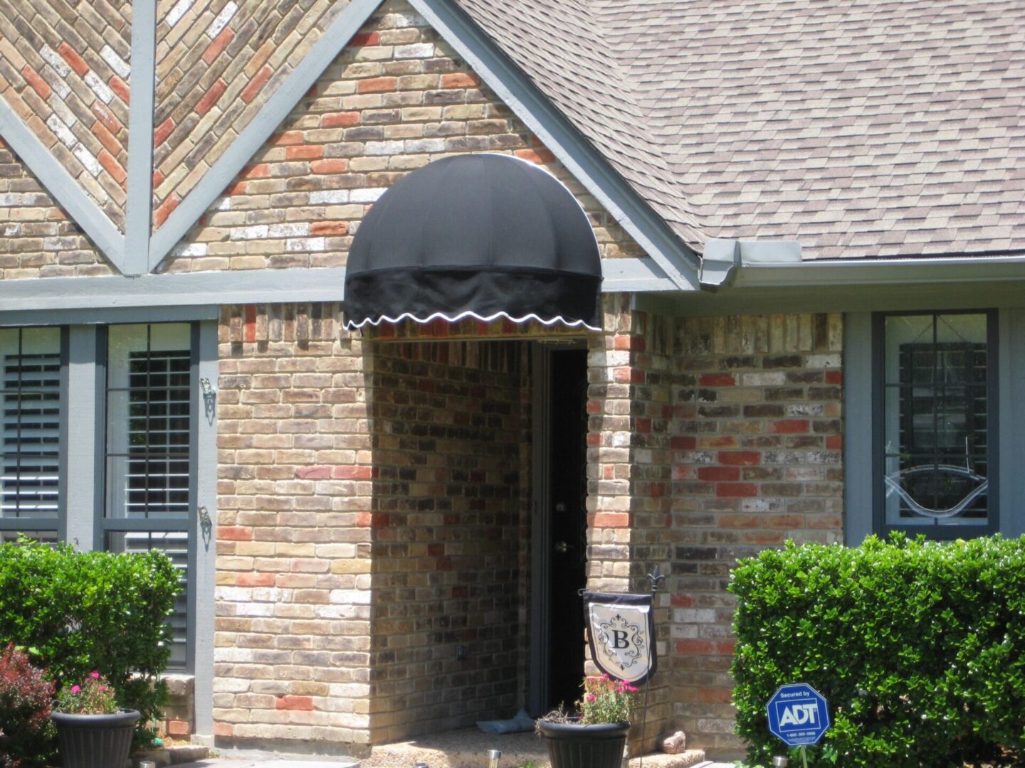 A small black awning covering the front door of a house